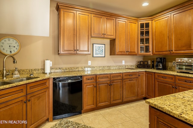 kitchen with light stone countertops, dishwasher, sink, and light tile patterned flooring