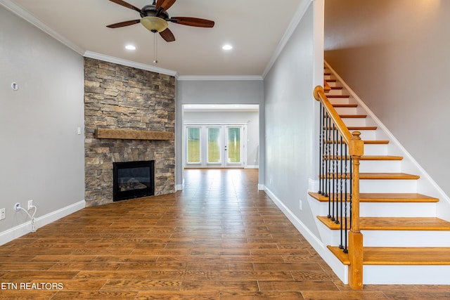 unfurnished living room featuring crown molding, ceiling fan, dark hardwood / wood-style floors, and a stone fireplace