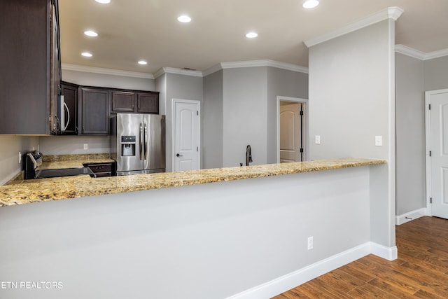 kitchen with dark brown cabinetry, stainless steel appliances, dark hardwood / wood-style floors, light stone counters, and crown molding