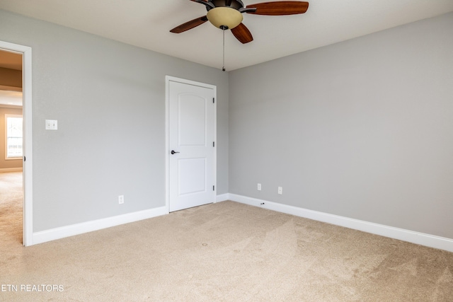 carpeted spare room with ceiling fan