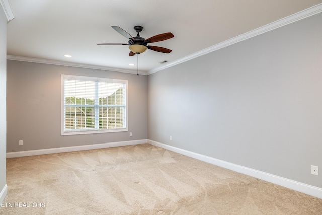 carpeted spare room with ceiling fan and ornamental molding