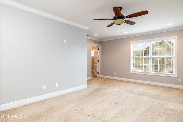 empty room featuring ceiling fan, light carpet, and crown molding