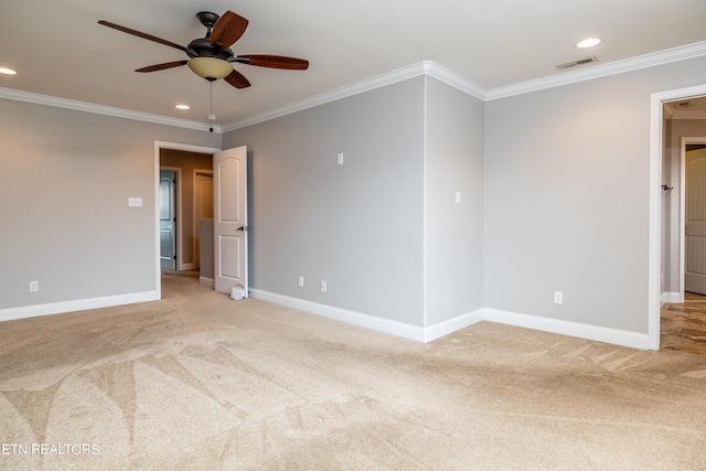 carpeted spare room featuring ceiling fan and crown molding