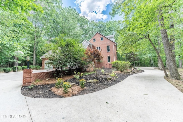 view of home's exterior featuring driveway and brick siding