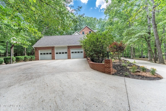 exterior space featuring brick siding, concrete driveway, roof with shingles, and an attached garage