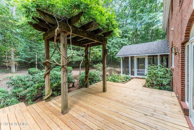 deck featuring a sunroom and a view of trees