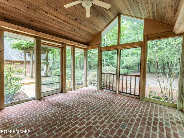 unfurnished sunroom featuring a healthy amount of sunlight, ceiling fan, vaulted ceiling, and wooden ceiling