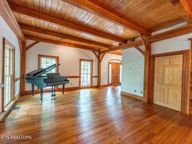 interior space with visible vents, beamed ceiling, and hardwood / wood-style flooring
