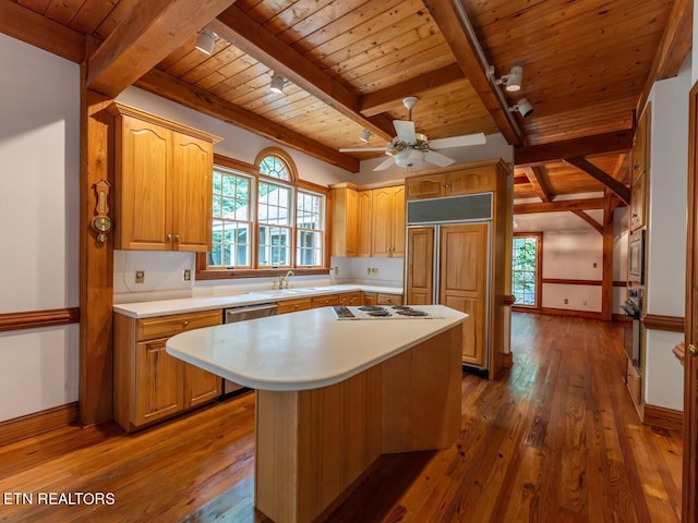 kitchen featuring light countertops, track lighting, dark wood-style floors, built in appliances, and wooden ceiling