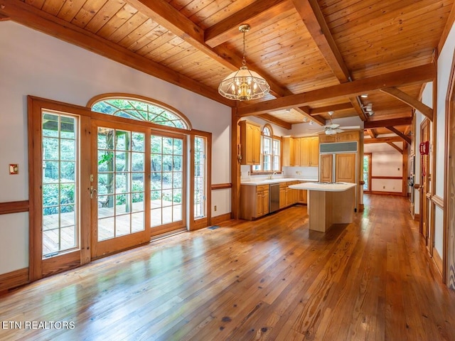 kitchen with light countertops, beamed ceiling, a kitchen island, wood ceiling, and wood-type flooring