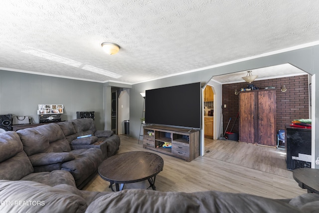 living room with a textured ceiling, ceiling fan, and ornamental molding