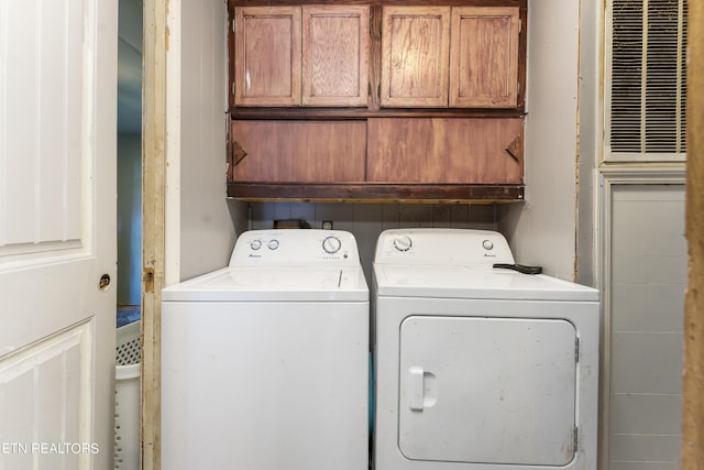 laundry room with washer and dryer and cabinets