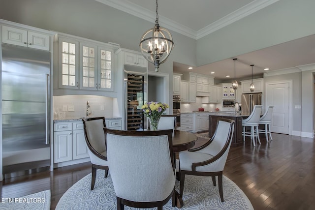 dining area with wine cooler, sink, dark hardwood / wood-style floors, a notable chandelier, and crown molding