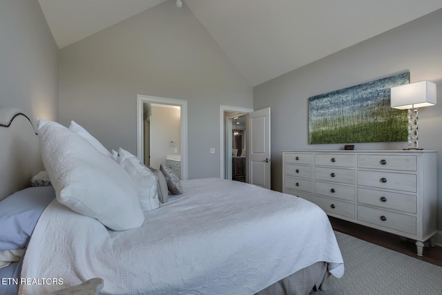 bedroom with high vaulted ceiling, ensuite bathroom, and dark hardwood / wood-style flooring