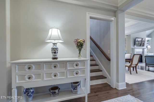 stairway with crown molding and wood-type flooring