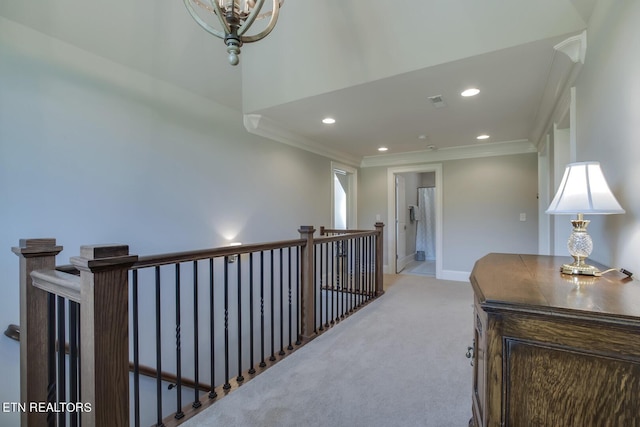 hallway featuring light carpet, an inviting chandelier, and crown molding