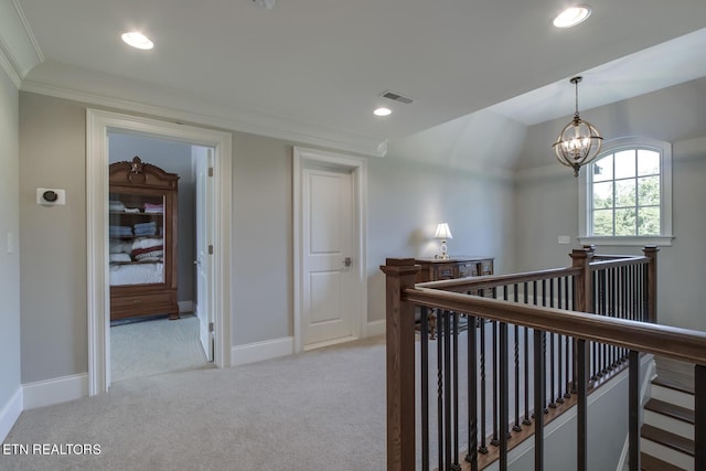 corridor with light colored carpet, a notable chandelier, and ornamental molding