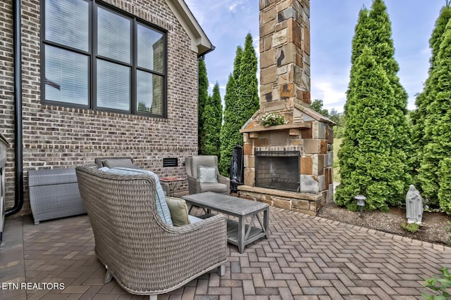 view of patio featuring an outdoor stone fireplace