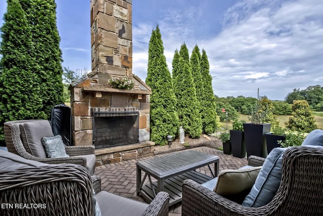 view of patio featuring an outdoor stone fireplace