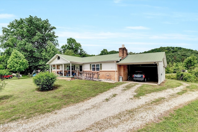 ranch-style house featuring covered porch, a front lawn, and a garage