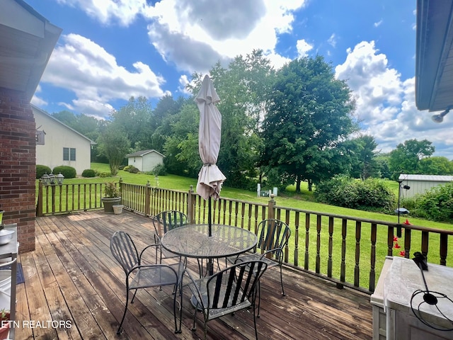 wooden terrace with a lawn