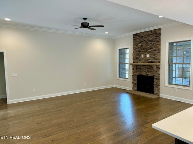 unfurnished living room featuring a fireplace, plenty of natural light, ceiling fan, and dark wood-type flooring