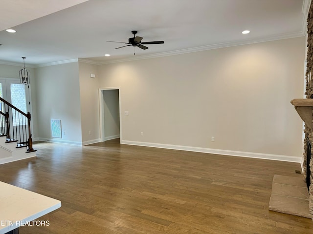 unfurnished living room featuring dark hardwood / wood-style floors, ceiling fan, crown molding, and a fireplace