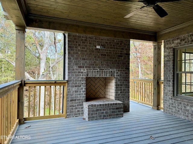 wooden terrace featuring an outdoor brick fireplace and ceiling fan