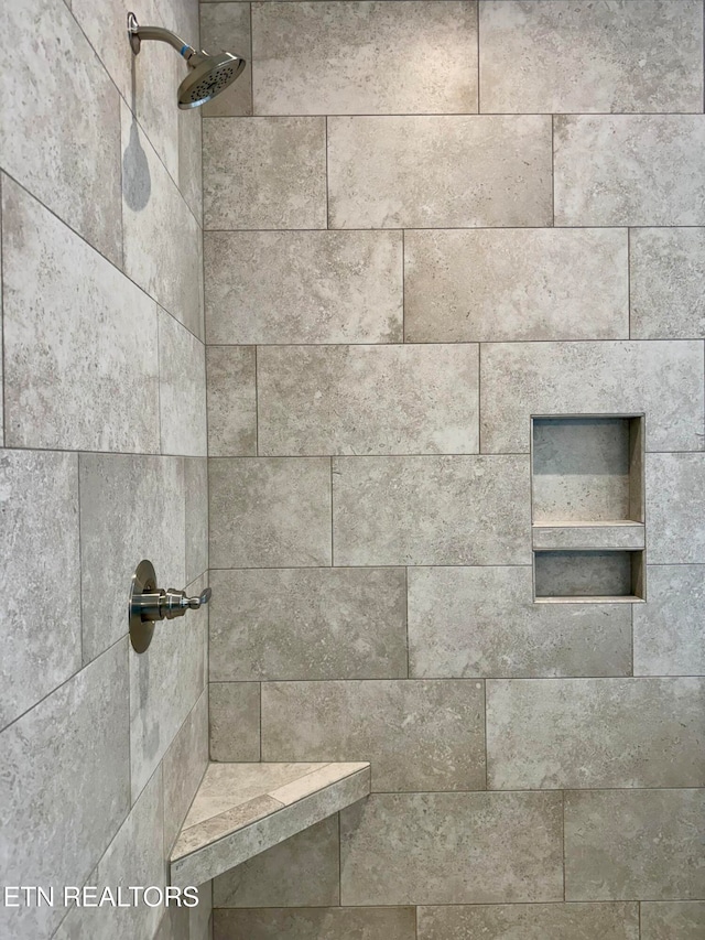 interior details featuring tiled shower