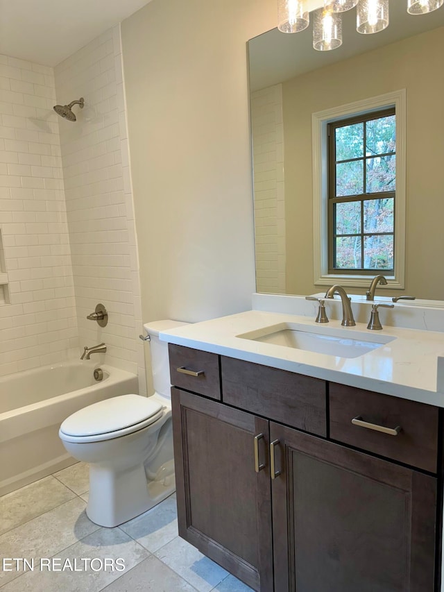 full bathroom with tile patterned floors, vanity, tiled shower / bath, and toilet