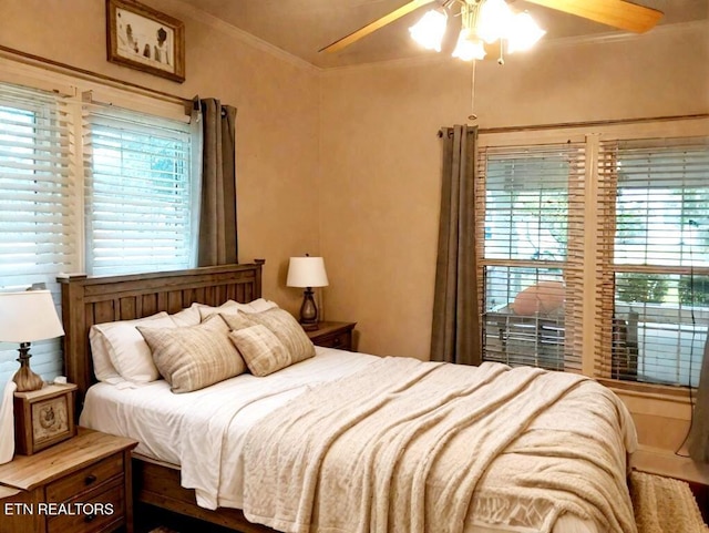 bedroom featuring multiple windows, ceiling fan, and ornamental molding