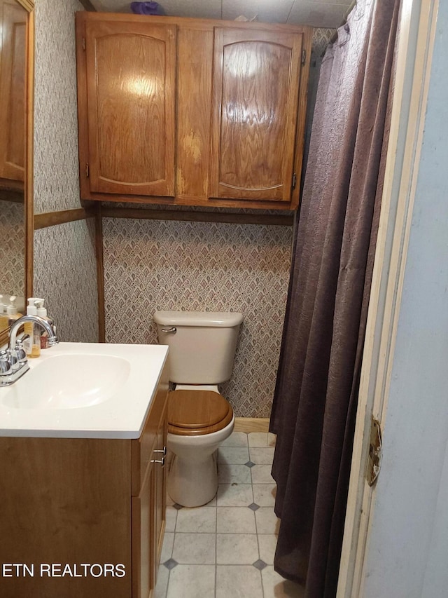 bathroom featuring tile patterned floors, vanity, and toilet