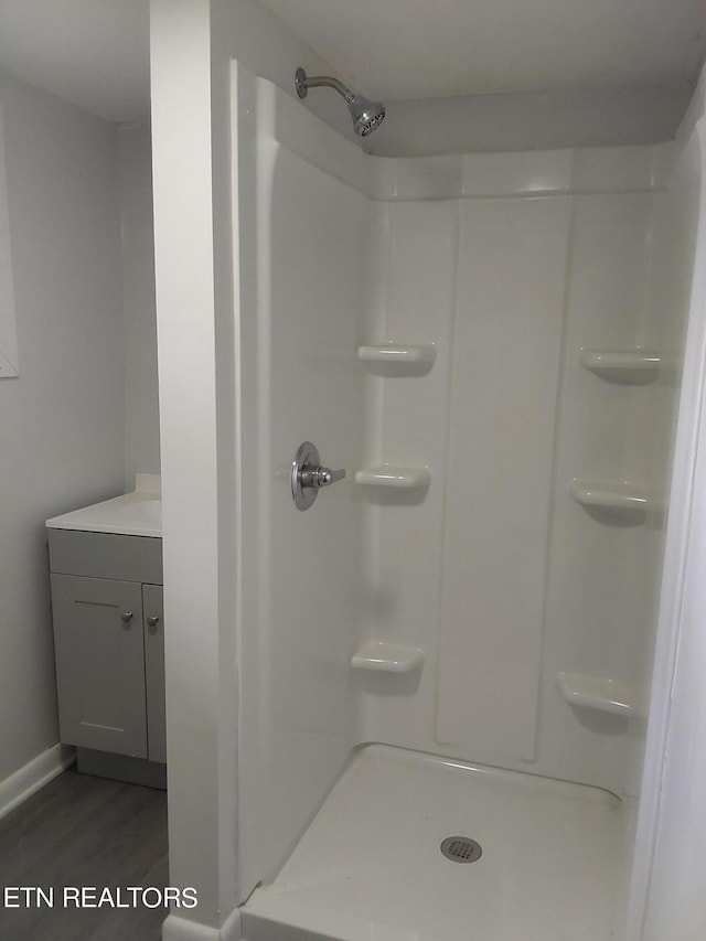 bathroom with vanity, wood-type flooring, and walk in shower