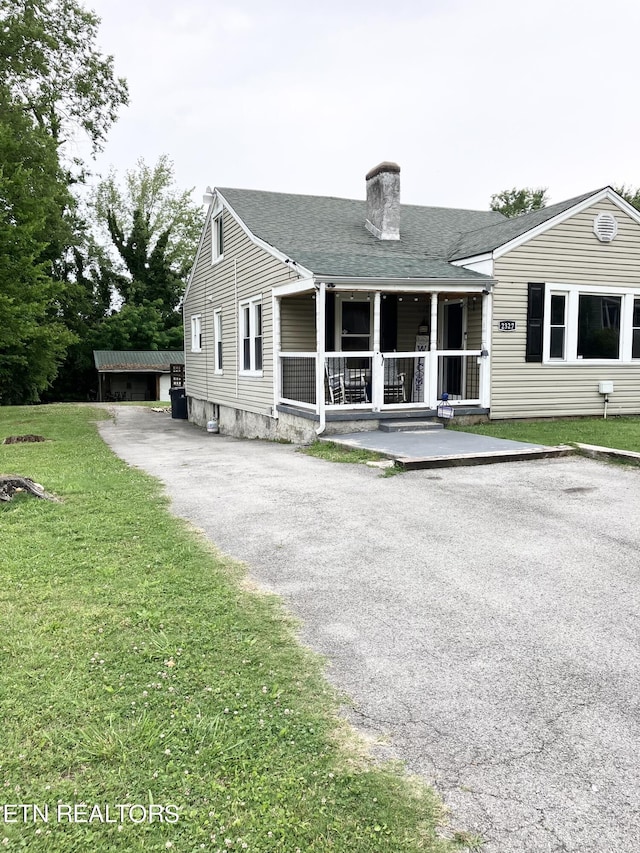 view of front of house featuring covered porch and a front lawn