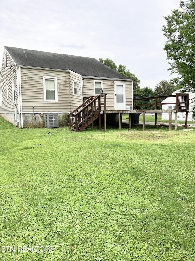 rear view of property with a lawn and central AC unit