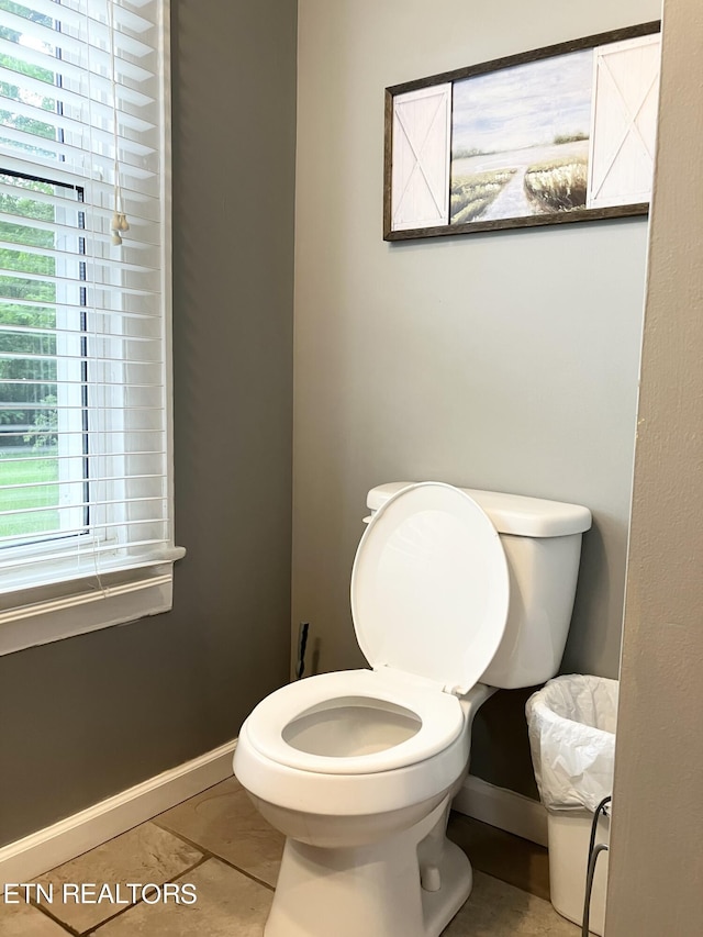 bathroom with toilet, tile patterned flooring, and plenty of natural light