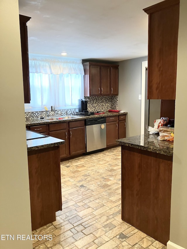 kitchen featuring stainless steel dishwasher, sink, backsplash, dark stone countertops, and dark brown cabinetry