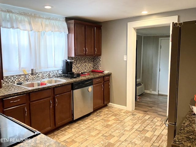 kitchen featuring sink, a wall mounted air conditioner, dark stone counters, and appliances with stainless steel finishes