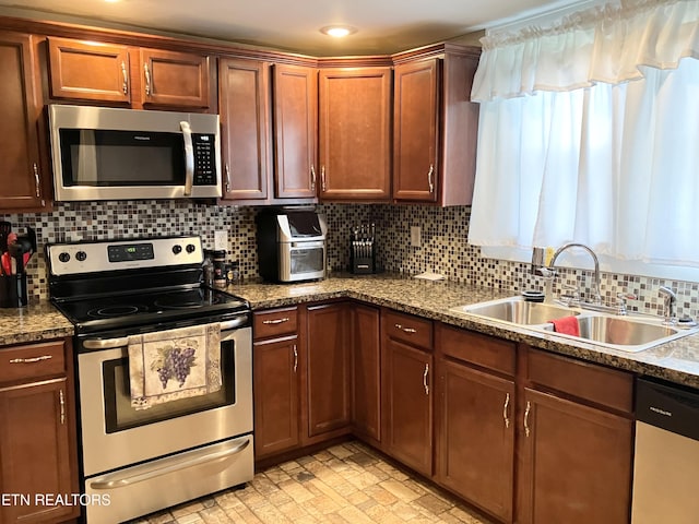 kitchen with appliances with stainless steel finishes, tasteful backsplash, and sink