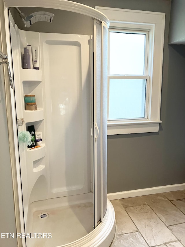 bathroom featuring an enclosed shower and a wealth of natural light