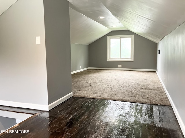 additional living space featuring vaulted ceiling and dark hardwood / wood-style floors