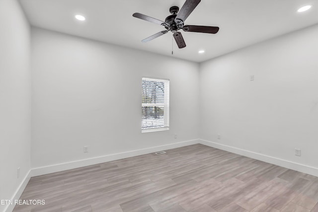 empty room with ceiling fan and light hardwood / wood-style floors