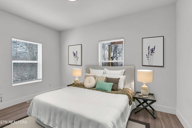 bedroom featuring wood-type flooring and multiple windows