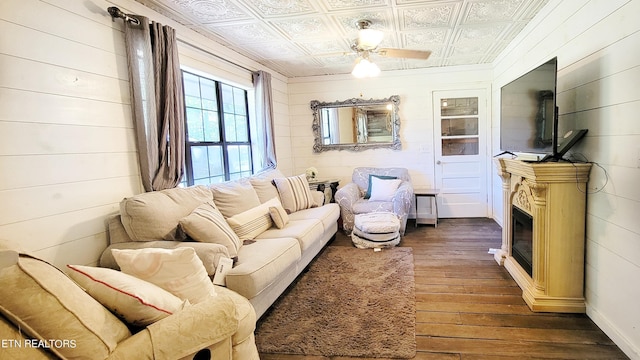 2109 Key Way, Sevierville, TN 37876 - living room featuring an ornate ceiling, dark wood-style flooring, wood walls, ceiling fan, and a glass covered fireplace