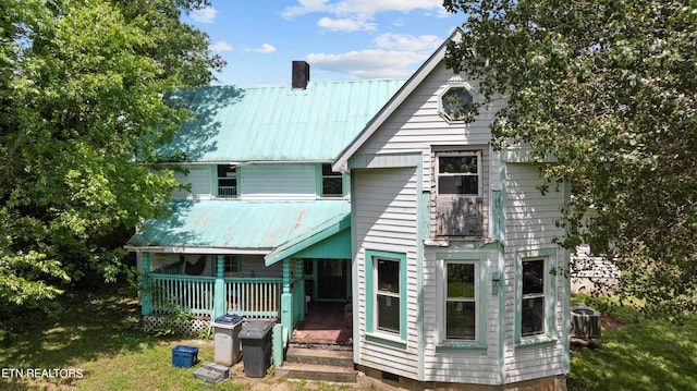 back of house featuring a porch and a yard