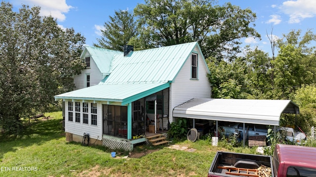 back of property featuring a sunroom and a yard