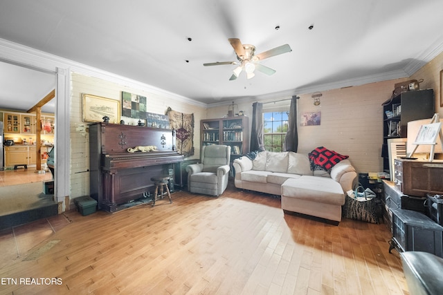 living room with ceiling fan, ornamental molding, and light hardwood / wood-style flooring