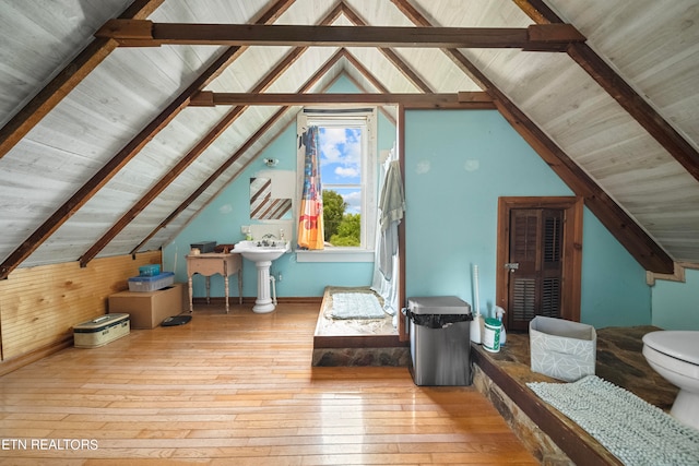 bonus room featuring sink, lofted ceiling with beams, and light wood-type flooring