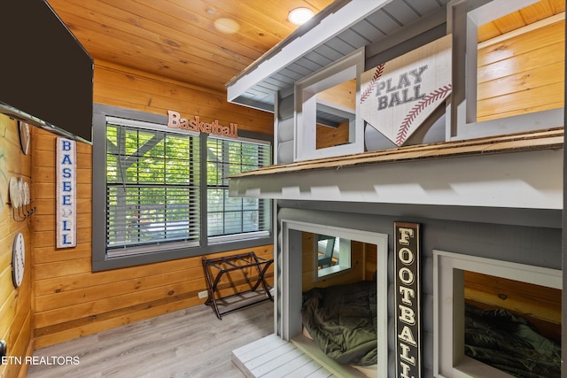 interior space with hardwood / wood-style flooring, wood walls, and wood ceiling