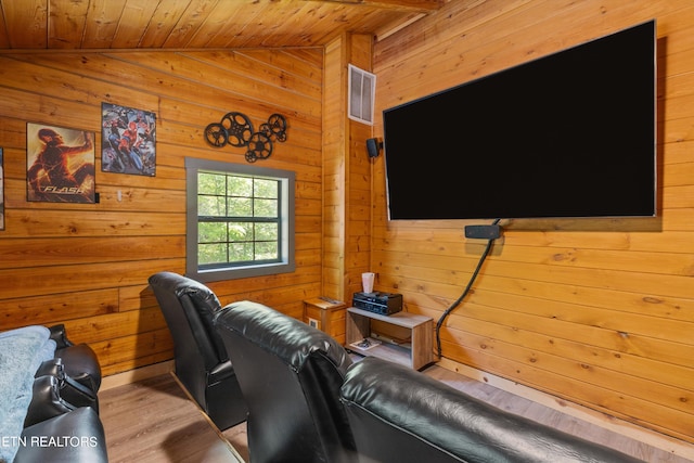 interior space with light hardwood / wood-style floors, wooden ceiling, wood walls, and vaulted ceiling